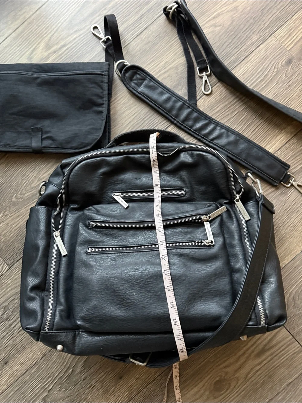 The Honest Company Black Vegan Leather Diaper Bag backpack model cross country